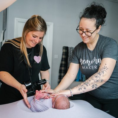 Lauren Shaw and Fru Jonas positioning a newborn's pose during training