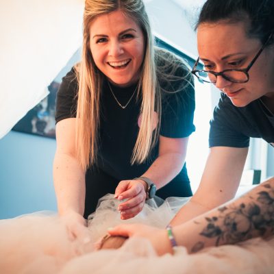 Lauren Shaw holding a newborn baby during photography training